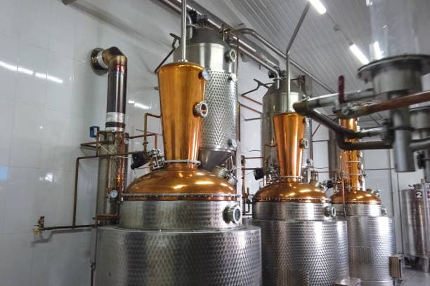 Gleaming copper pot stills during the distillation process